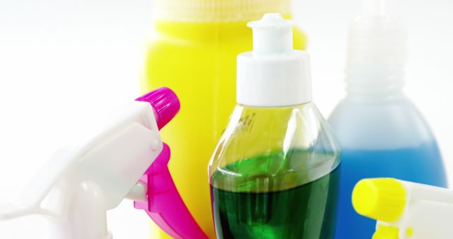 Colorful cleaning supplies, including spray bottles and a soap dispenser, are arranged closely together, with copy space. These items are essential for maintaining cleanliness and hygiene in various settings.