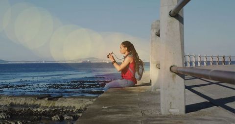 Woman with Binoculars Sitting at Promenade with Sun Flares - Download Free Stock Images Pikwizard.com