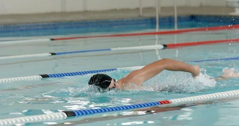 Male Swimmer Practicing Freestyle in Indoor Pool Lanes