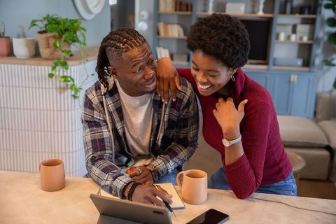 Couple Enjoying Relaxing Morning with Notebook and Tablet