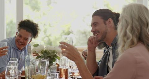 Joyful Wedding Reception with Friends Laughing and Toasting Wine