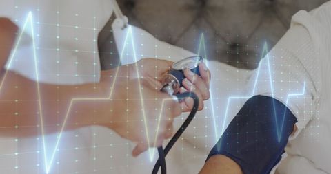 Doctor checking blood pressure with heart monitor overlay