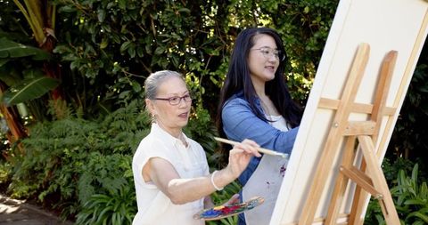 Senior Adult Mentoring Young Artist in Tropical Garden Setting