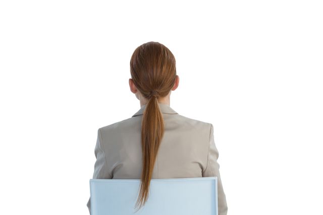 This image shows a businesswoman with red hair sitting on a chair, viewed from the back. She is wearing professional business attire, making it suitable for use in corporate presentations, business websites, career-related articles, and office-themed marketing materials.