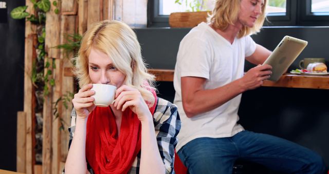 Young Woman Enjoying Coffee Beside Man Using Tablet in Cafe - Download Free Stock Images Pikwizard.com