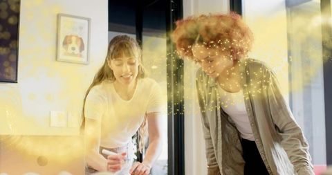 Two women collaborating over sketches with golden light overlay, creative teamwork concept