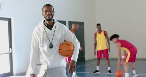 Basketball Coach Overseeing Players During Training Session in Gym