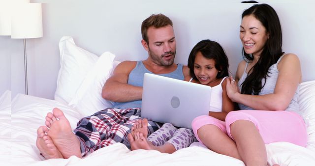 Family bonding during leisure time, using laptop for entertainment or education. Perfect for promoting family products, online streaming services, or educational tools.