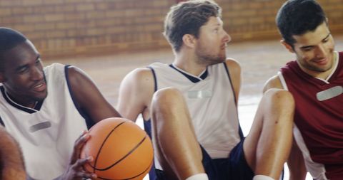 Diverse group of young men relaxing on basketball court