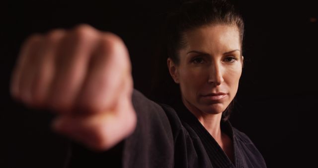 Confident Woman Throwing Punch in Martial Arts Uniform - Download Free Stock Images Pikwizard.com