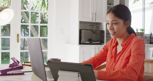 Biracial woman sitting at table and working with laptop. Beauty, health and female spa home concept.