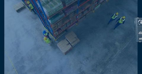 Warehouse employees organizing transport boxes on elevated racks platform