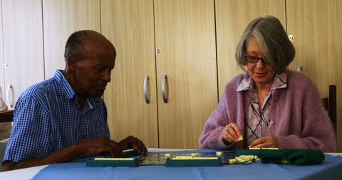 Seniors engaging in puzzle game at retirement home