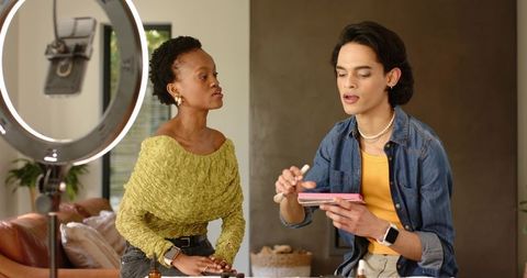 Filming diverse beauty creators demonstrating makeup tutorial with palette and ring light