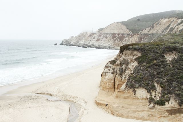Coastal Landscape of Rocky Cliffs and Sandy Beach on Overcast Day - Download Free Stock Photos Pikwizard.com