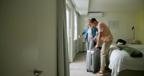 Couple Embracing by Window Admiring Morning View in Bedroom