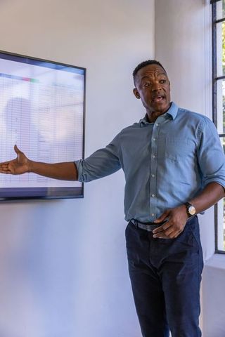 Confident professional presenting financial spreadsheet in office