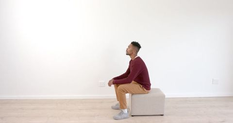 Young Man Performing Indoor Squat for Fitness