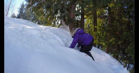 Boy Climbing Snowy Hill on Winter Adventure