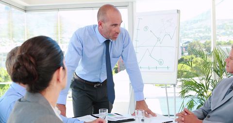 Businessman Presenting Charts in Office Meeting - Download Free Stock Images Pikwizard.com
