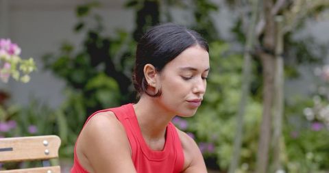 Serene Woman Resting on Garden Bench in Tranquil Setting