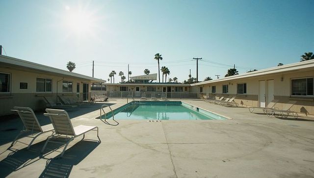 Vintage motel courtyard with pool under bright sun