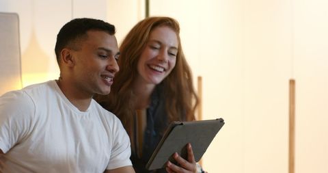 Couple announcing engagement while video chatting on tablet
