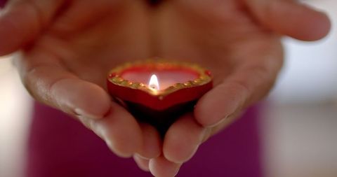 Hands Holding Decorative Candle for Diwali Celebration