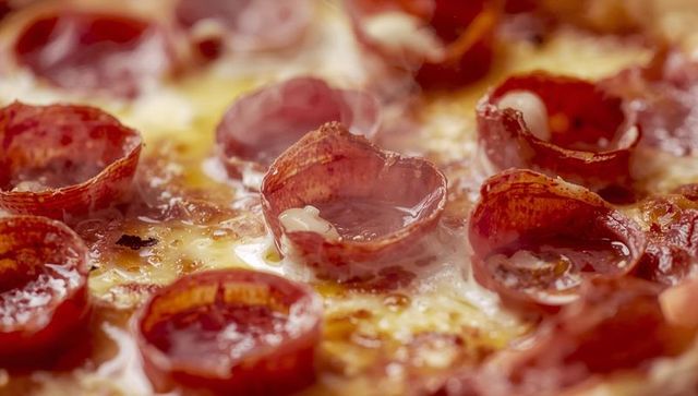 Sizzling pepperoni cup pizza with golden melted cheese and oozing pepperoni cups