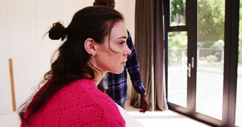 Diverse Couple Deep in Thought by Window