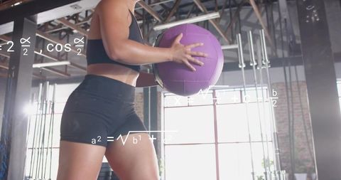 Woman holding purple medicine ball training core strength in gym with math overlay