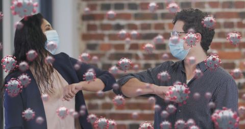 Office workers greeting with elbow bump amid covid-19 pandemic