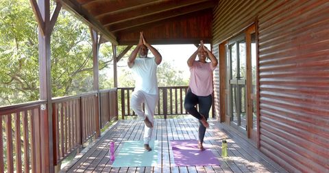 Senior African American Couple Doing Yoga on Sunlit Porch