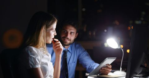 Late night office work with digital tablet