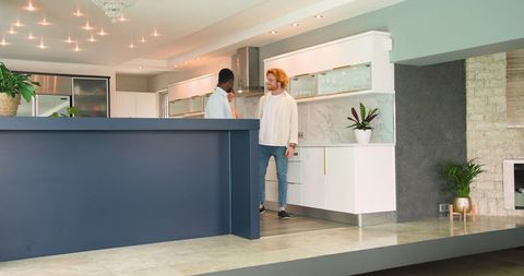 Couple and estate agent discussing house purchase in modern kitchen