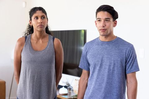 Young african american couple standing in modern living room looking thoughtful