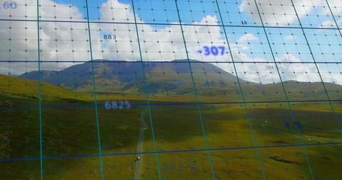 Aerial landscape displaying mountain ridge and moorland with blue mapping grid overlay