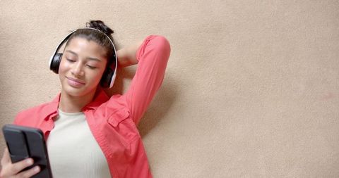Biracial Teen Relaxing With Headphones and Smartphone