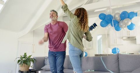 Joyful Mature Couple Dancing Together at Home Celebration
