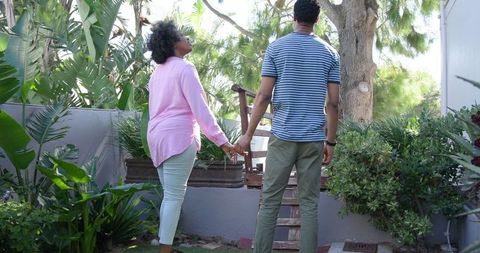 Couple's romantic proposal moment with lush greenery backdrop