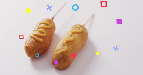 Playful corn dogs with mustard and geometric shapes
