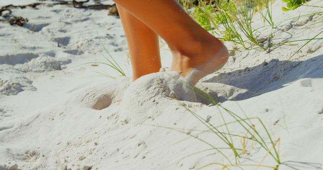 Bare feet walk on a pristine white sandy beach, evoking a sense of relaxation and connection with nature. It's a moment that captures the carefree essence of a beach holiday or a leisurely day by the sea.