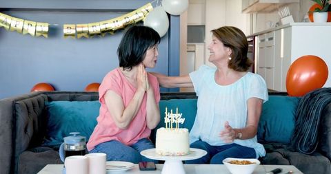 Senior Friends Celebrating Birthday with Cake and Balloons Smiling