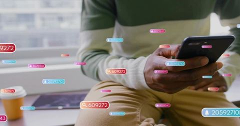 Man holding smartphone near window with modern ui notification overlays, tablet and coffee