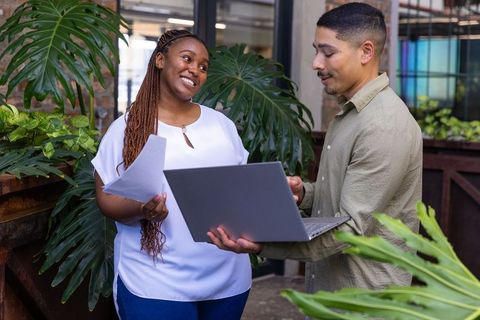 Diverse Coworkers Collaborating in Plant-Filled Modern Office