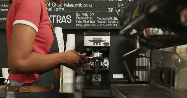 Image shows barista using an espresso machine, grinding coffee beans, and making espresso. Ideal for articles and posts about coffee culture, barista skills, cafe businesses, and training materials for cafe employees.