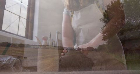 Artisan baker kneading dough with scenic rural overlay