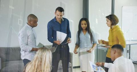 Team collaborating on analytics presentation for business strategy in modern office huddle