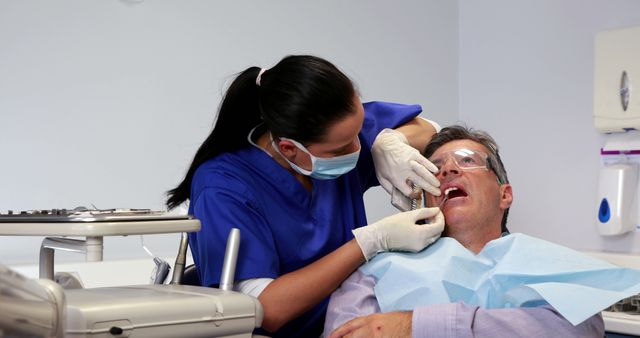 Professional Dentist Examining Male Patient in Modern Clinic - Download Free Stock Images Pikwizard.com