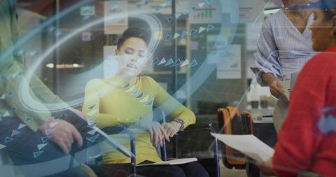 Businesswoman in wheelchair checking watch during team office meeting with digital charts